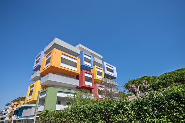 Un immeuble à étages doté d’une architecture originale, caractérisé par une série de sections rectangulaires superposées de différentes couleurs.