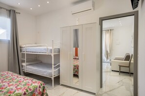 Un dormitorio con una cama litera, un armario y un espejo en la puerta del closet.