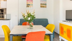 A dining area with a table, chairs, and a vase of flowers.