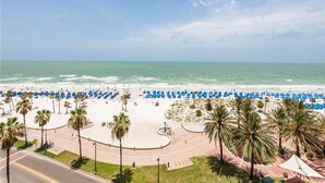 Una playa con sombrillas azules y palmeras.