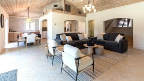 Un espacio habitable amplio con techo alto, comedor y cocina.