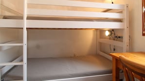 Una cama litera con escritorio y lámpara.