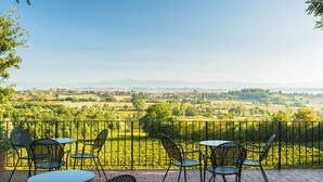 Eine Terrasse mit Sitzgelegenheiten und Blick auf eine ländliche Landschaft.
