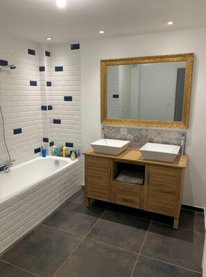 Bathtub, hair dryer, towels, toilet paper