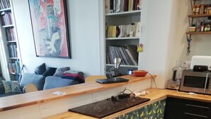 A kitchen with a wooden countertop, a microwave, and a patterned curtain. - Spacious 120 m2, 4 bedrooms with garages and Saône view. (Lyon)
