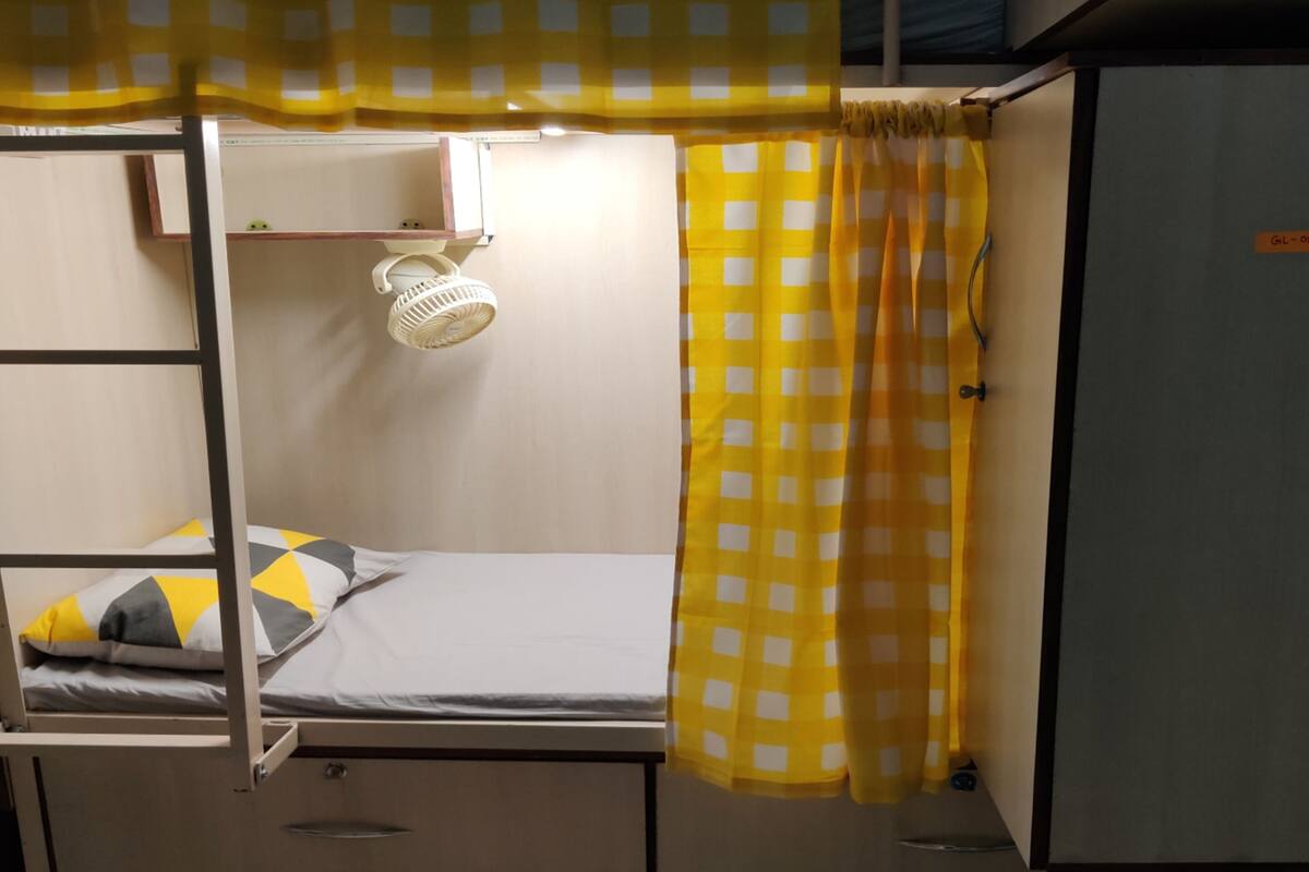 A bunk bed with a headboard, a small shelf, and a heater.