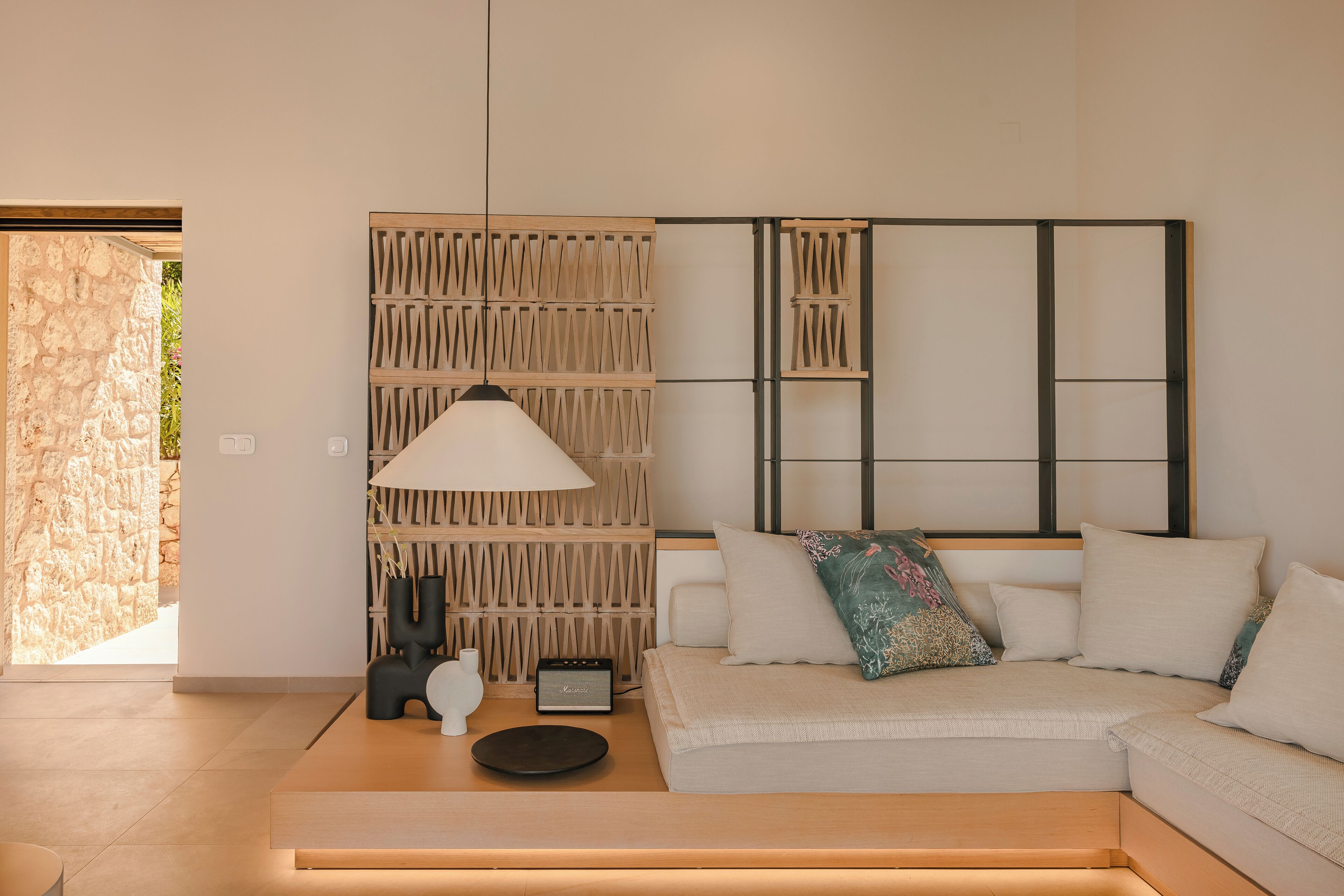 Ein modernes Wohnzimmer mit einer Couch, einer Lampe und einer Wandverkleidung.