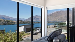 A modern room with large windows overlooking a lake and mountains. - St Matthews Views - Cecil (Queenstown)