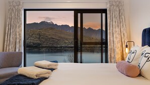 A bedroom with a large window offering a mountain view. - St Matthews Views - Cecil (Queenstown)