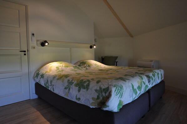 A bedroom with a bed, bedside lamps, and a ceiling fan.