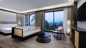 Una habitación de hotel moderna con una cama grande, un sofá, una mesa de comedor y una televisión.