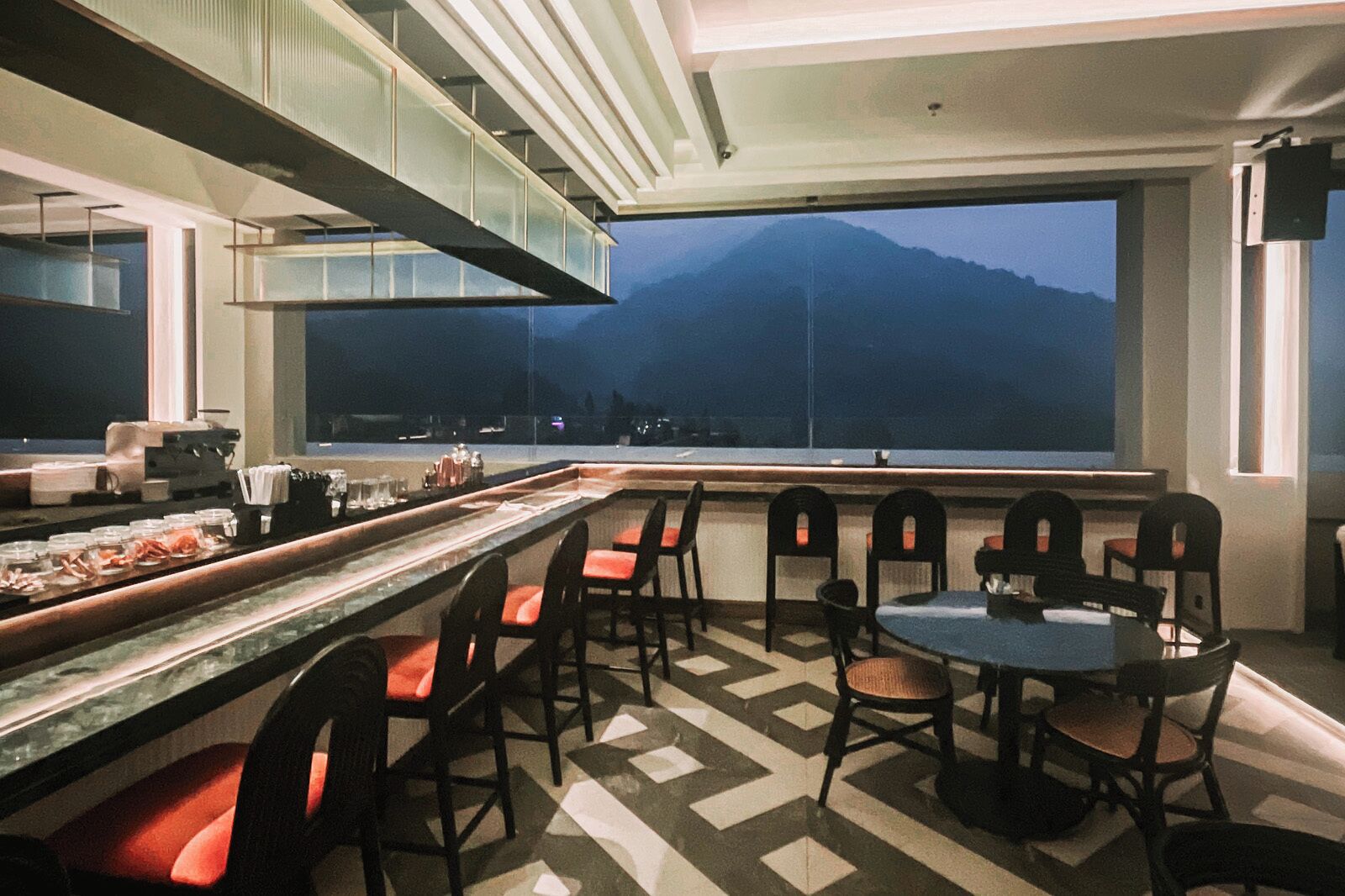 Un restaurante con barra, sillas y una mesa.