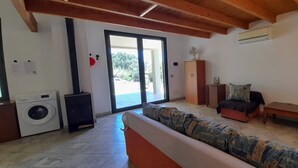 Una sala de estar con sofá, televisor, lavadora y ventilador.