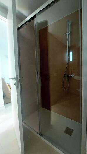 A modern bathroom with a glass-enclosed shower, a visible drain, and a door handle. - New Miami Playa Apartaments (San Bartolomé de Tirajana)