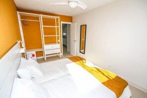 A bedroom with a bunk bed, a wardrobe, a mirror, and a ceiling fan. - New Miami Playa Apartaments (San Bartolomé de Tirajana)