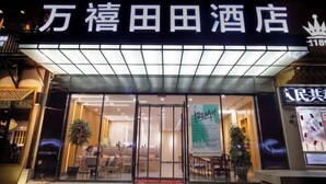 A hotel entrance with a sign in a foreign language, glass doors, and indoor seating visible through the entrance. - Wanxi Tiantian Hotel (Shenyang)