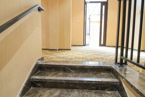 A marble staircase leading to a door with a metal railing. - Wanxi Tiantian Hotel (Shenyang)