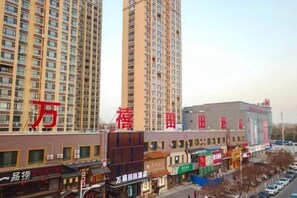 A high-rise building with multiple floors and a commercial area below. - Wanxi Tiantian Hotel (Shenyang)