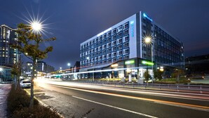 A multi-story hotel with a modern design, featuring a prominent sign and illuminated windows.