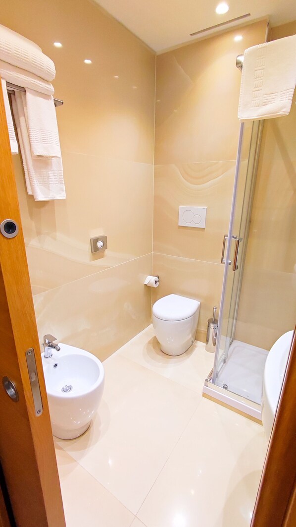 A modern bathroom with a glass shower enclosure, a pedestal sink, and a toilet. - Catania Sea Palace Hotel (Catania)