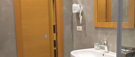 Ein modernes Badezimmer mit einem großen Waschbecken, einer Toilette und einem Bidet.