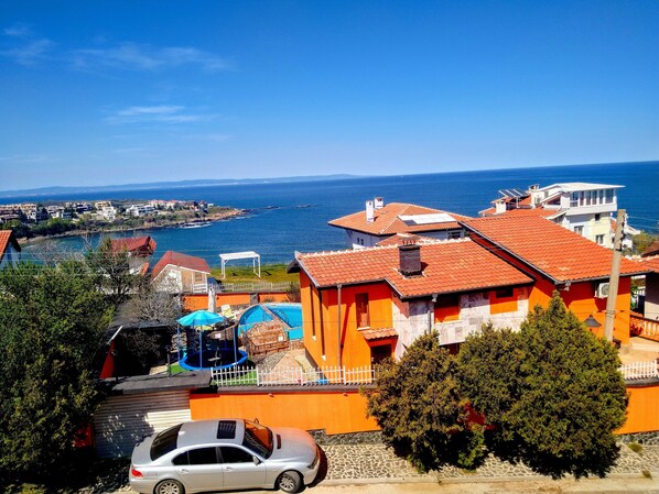A coastal residential area with houses, a swimming pool, and a view of the sea.