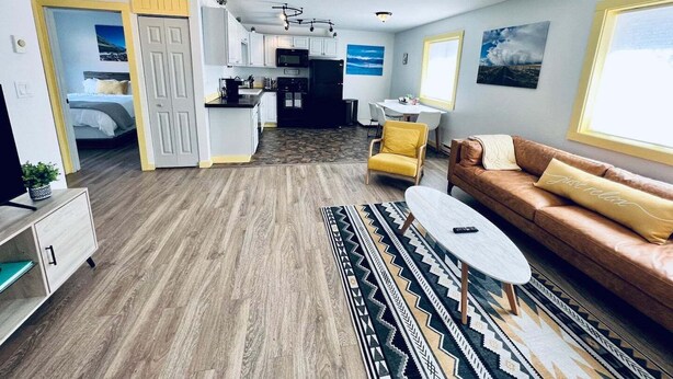 A modern living room with a sofa, a coffee table, and a patterned rug. - Glacier Lake 2nd floor 2 bdrm condo (Joseph)