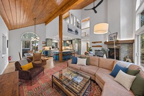 A spacious living area with a large sofa, a coffee table, and a fireplace.