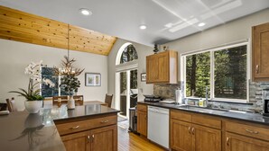 A modern kitchen with wooden cabinets, a black countertop, and a skylight. - Chic Pet-Friendly Retreat | King Suite, Hot Tub | Clubhouse Access | Near Lake (Truckee)