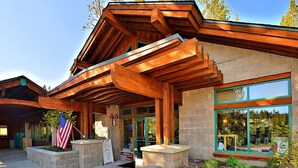 A lodge with a wooden exterior, stone foundation, and large windows. - Chic Pet-Friendly Retreat | King Suite, Hot Tub | Clubhouse Access | Near Lake (Truckee)