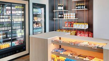 A beverage and snack display area with refrigerated drinks and packaged snacks.