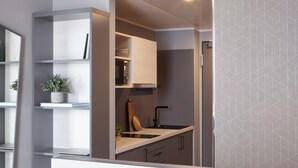 A modern kitchen with built-in cabinets, a countertop, and a sink. - Candlewood Suites Dusseldorf Airport by IHG (Düsseldorf)