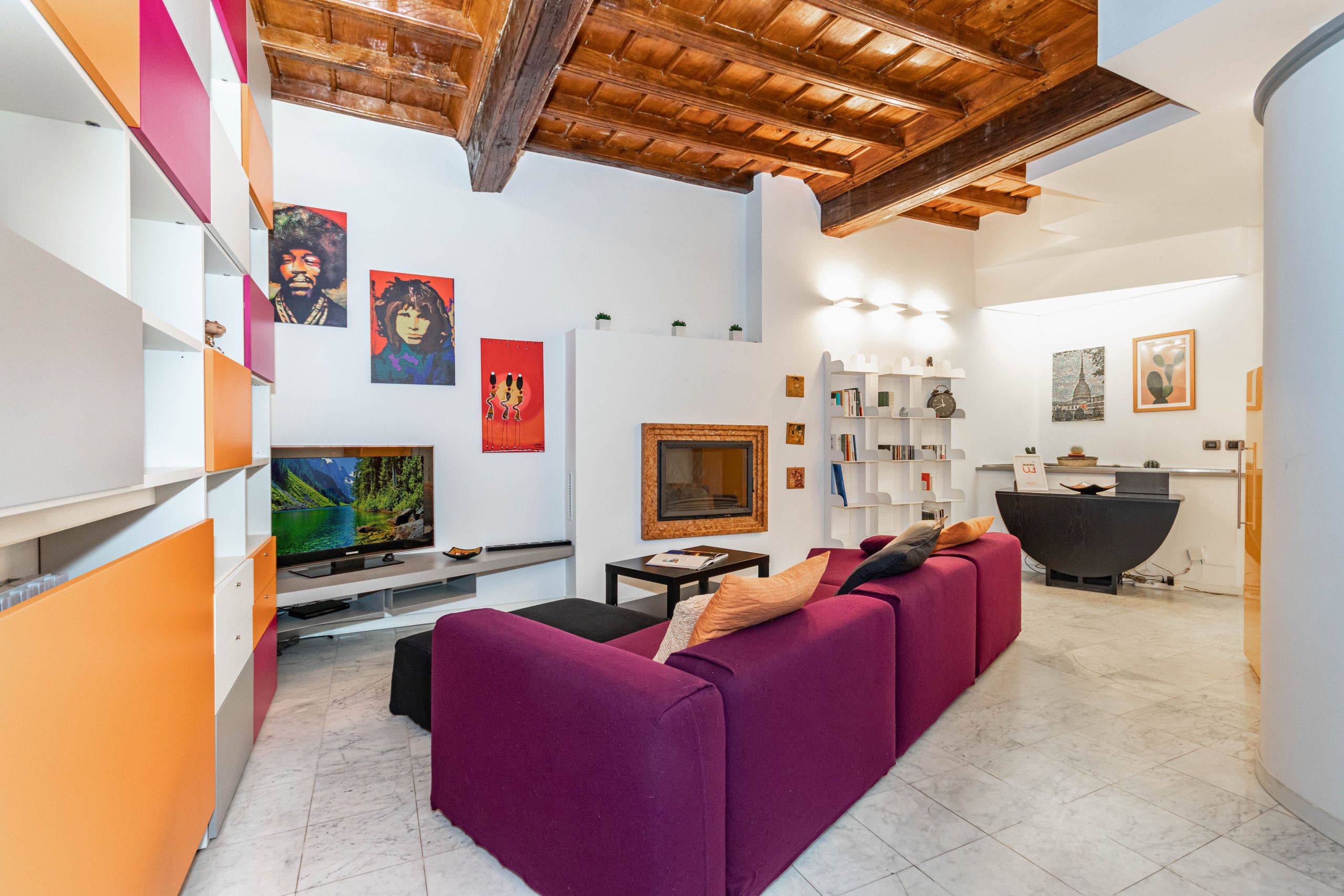A modern living room with a fireplace, a television, and a reception desk.