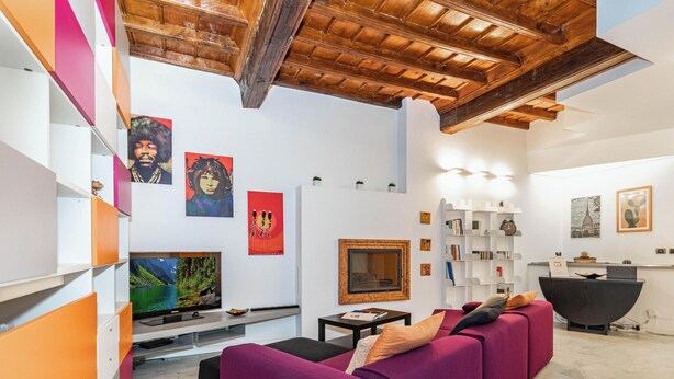 A modern living room with a purple sofa, a flat-screen TV, and artwork on the walls. - Central Pop House by Wonderful Italy (Torino)