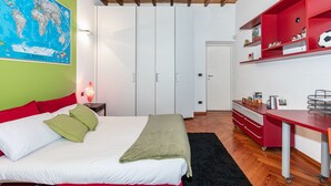 A bedroom with a bed, a desk, a wardrobe, and a world map on the wall. - Central Pop House by Wonderful Italy (Torino)