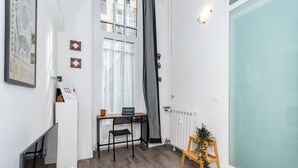 A modern, well-lit room with a desk, chair, and a small plant. - That's a Mole by Wonderful Italy (Torino)