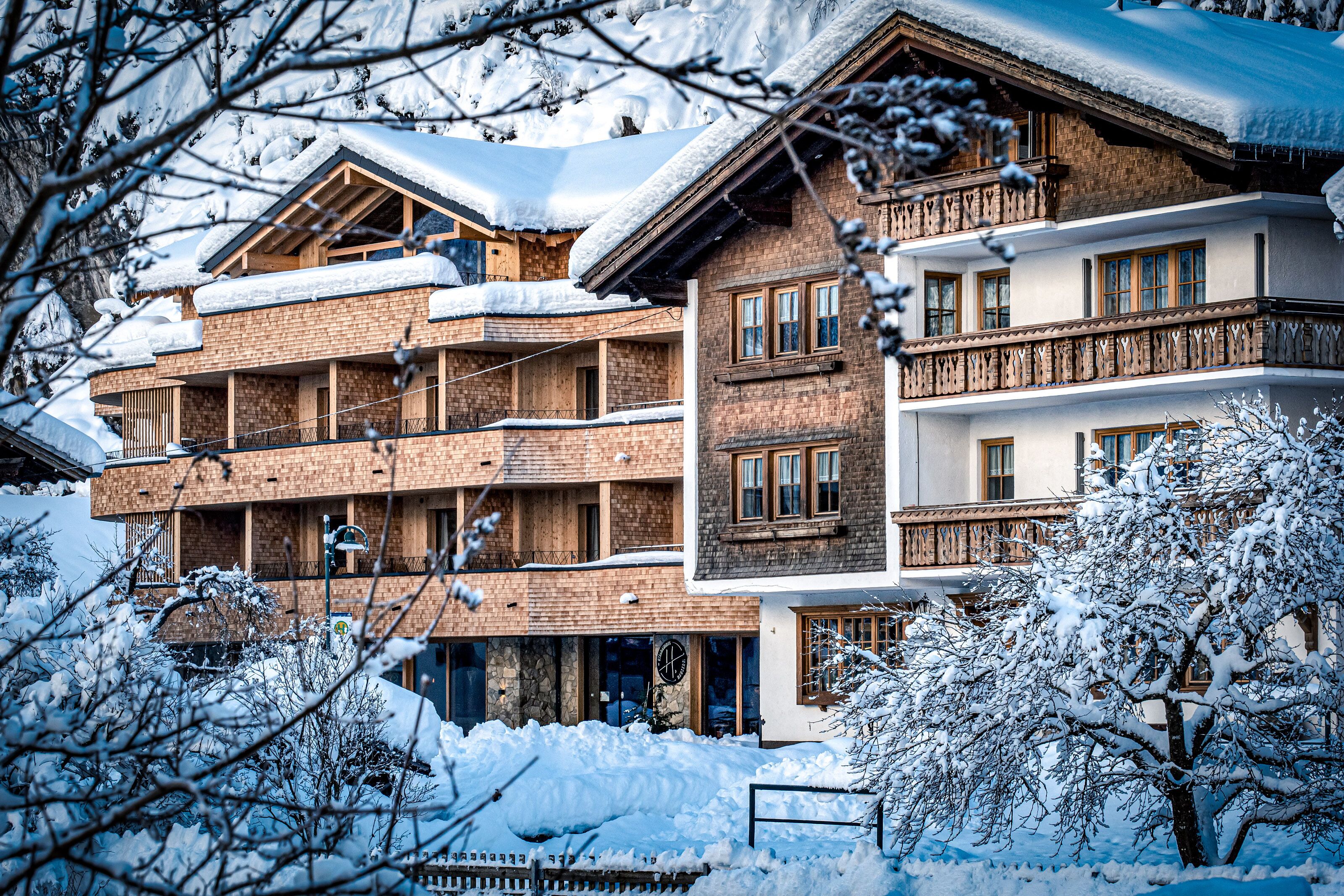 A multi-story building with balconies and a snow-covered roof.