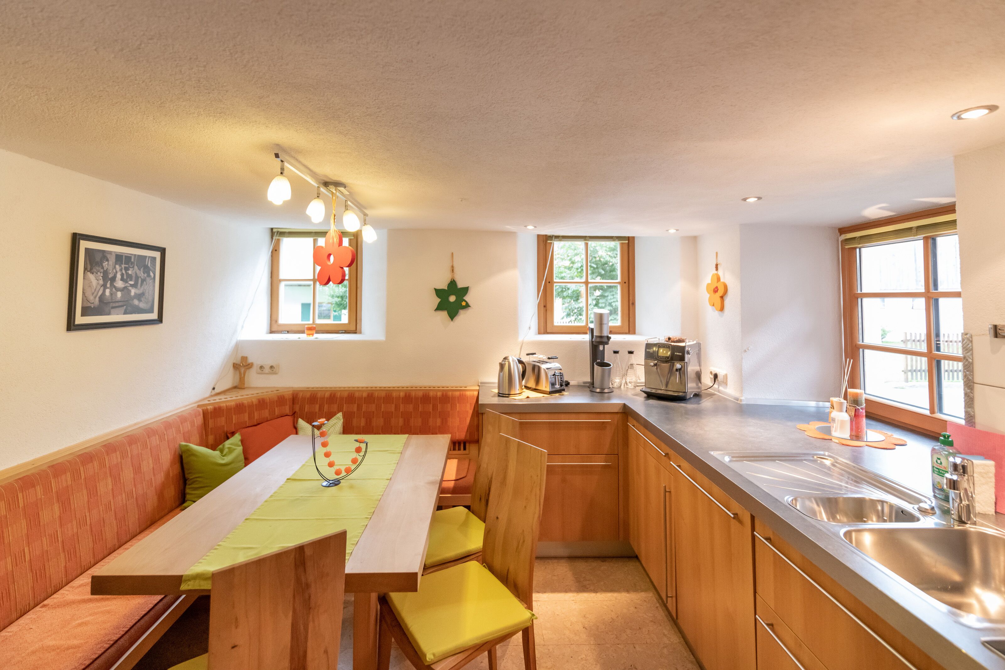 A compact kitchen with a wooden bench, a dining table, and a sink.