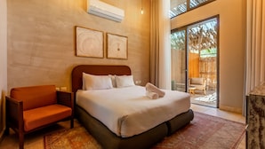 Une chambre d’hôtel avec un lit, une chaise, un climatiseur et une vue sur l’extérieur.