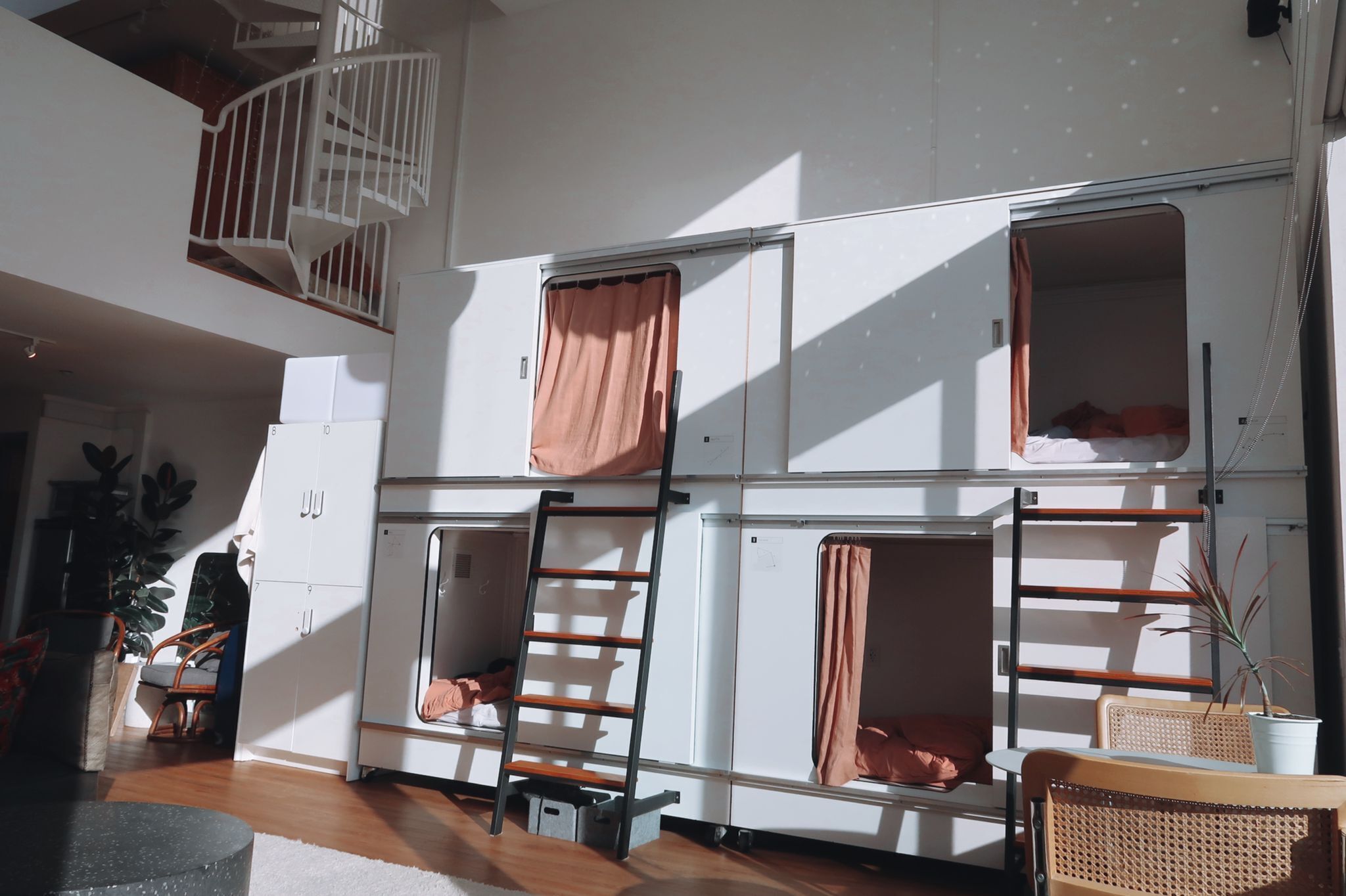 Habitación compacta con literas, una escalera y una pequeña zona de estar.