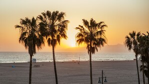 A beach with palm trees and a lifeguard tower.