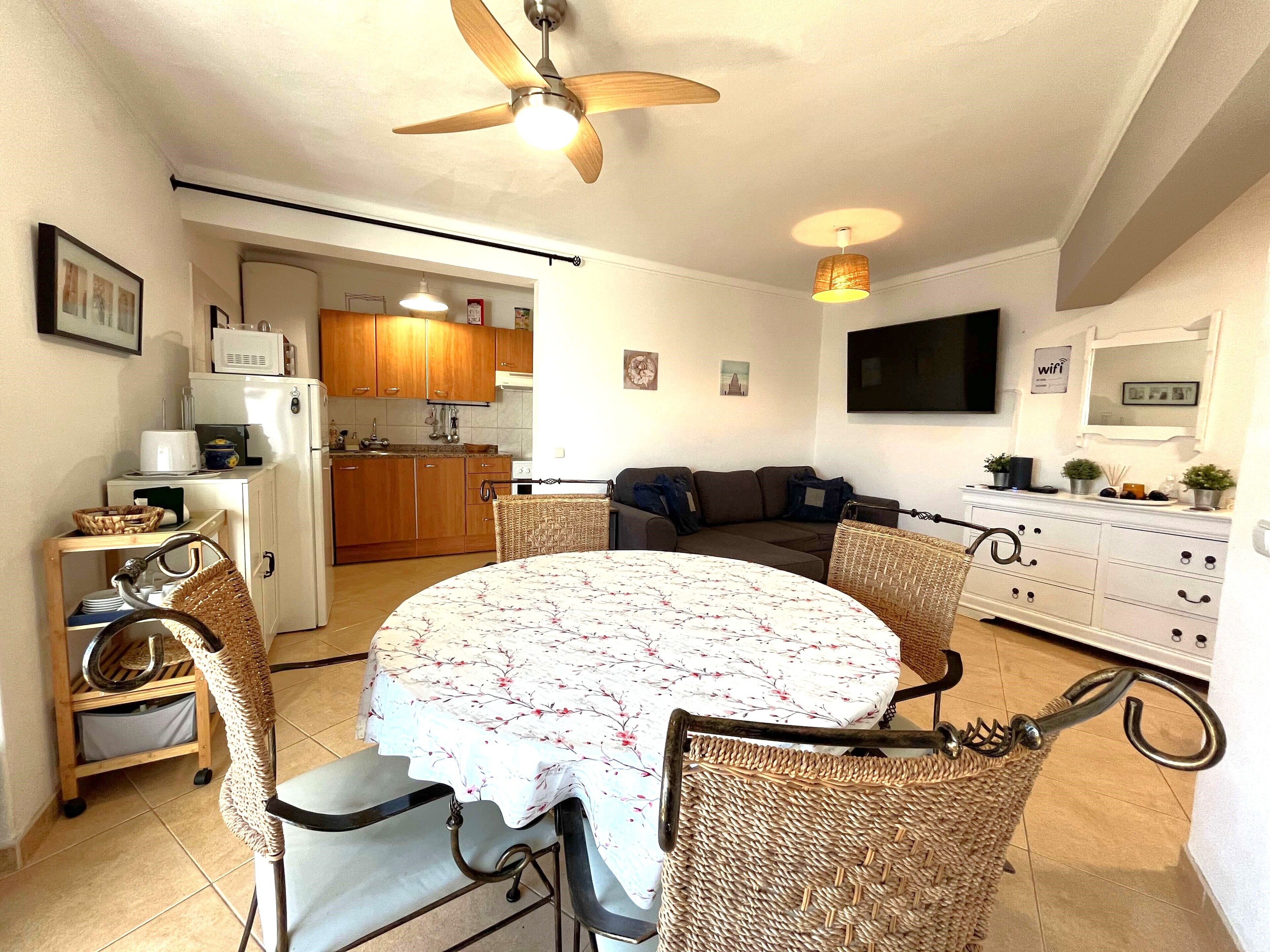 A compact living space with a dining area, kitchenette, and a sofa.