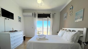 Una camera d'albergo con un letto, una scrivania, una televisione e una finestra vista.