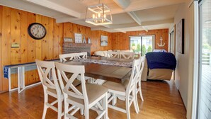 A dining area with a wooden wall, a clock, and a chandelier. - The Swedish Fish: Getaway on Lake Saint Clair! (Olympia)