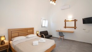 Habitación de hotel con cama de madera, lámparas de noche, un escritorio con silla, televisión y ventana.