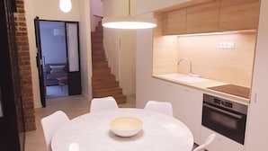 A modern kitchen with white cabinets, a built-in oven, and a wooden countertop. - Charles V, 2BD/ 2BA, 6 people (París)