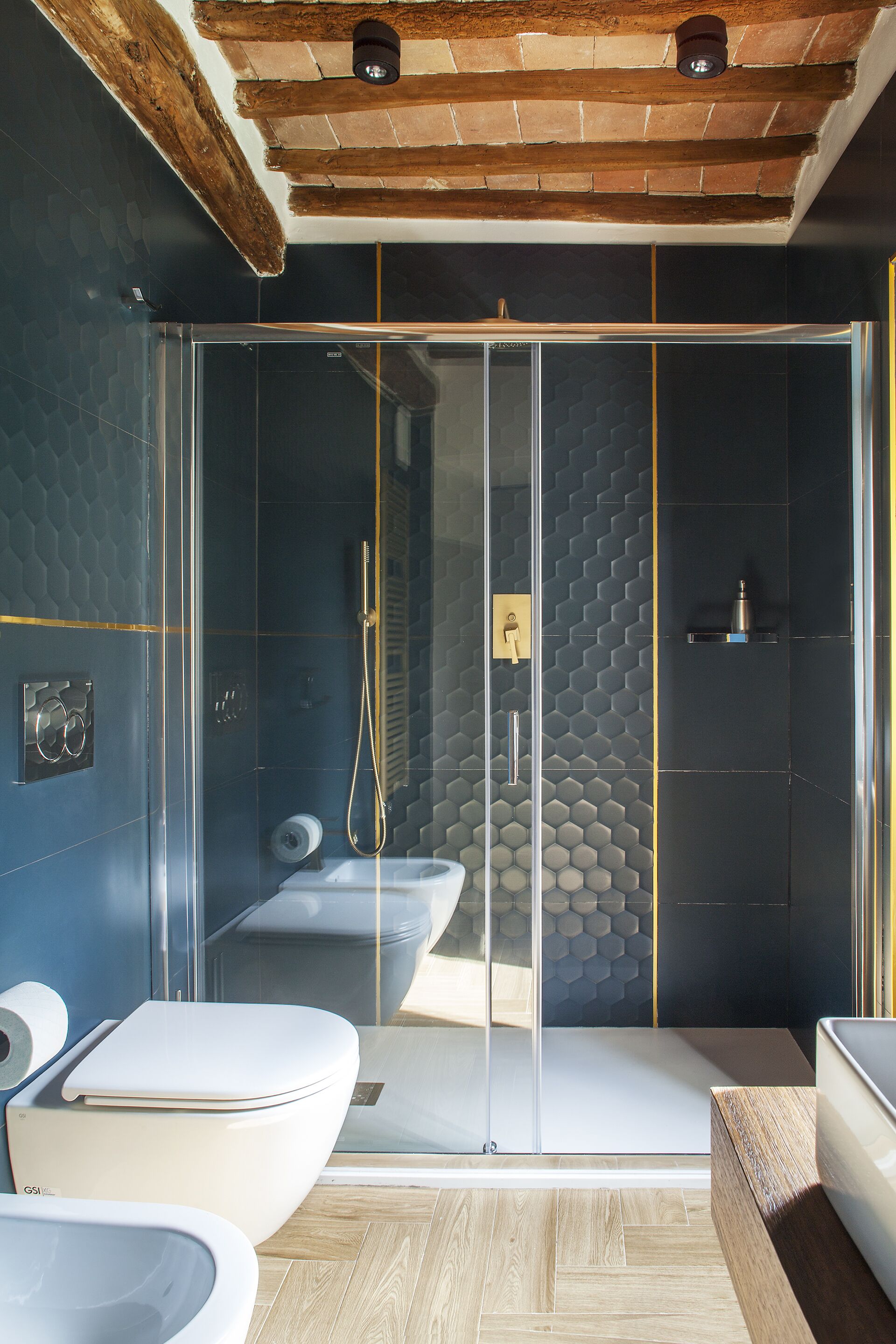 A modern bathroom with a glass-enclosed shower, a toilet, and a sink.