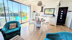 Une cuisine moderne avec des meubles blancs, une cuisinière noire et une fenêtre donnant sur un jardin.