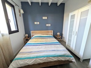 Una camera da letto con un letto, due comodini, un armadio e due lampade a parete.