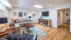 A modern living room with a sofa, coffee table, and TV stand.